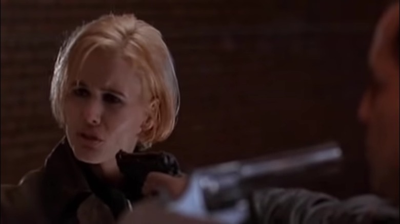 Samantha and a man point guns at each other
