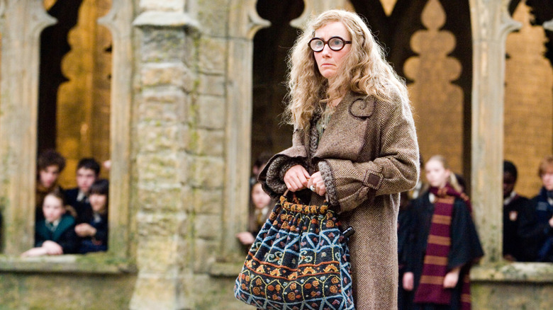 Professor Trelawney in the Hogwarts yard holding her bag and looking sad in Harry Potter and the Order of the Phoenix