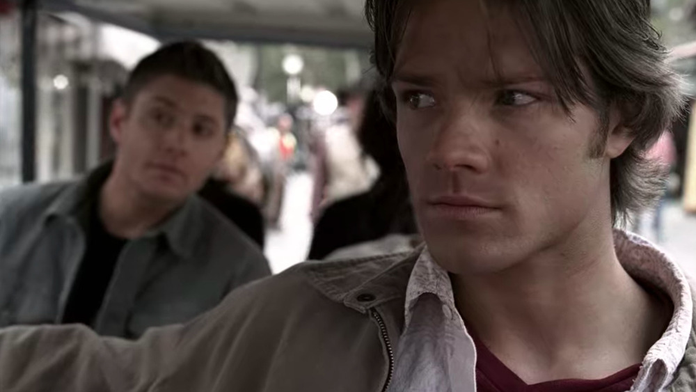 Sam Winchester looking nervous as Dean looks on intrigued