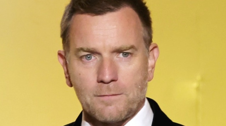 Ewan McGregor wears suit yellow backdrop 