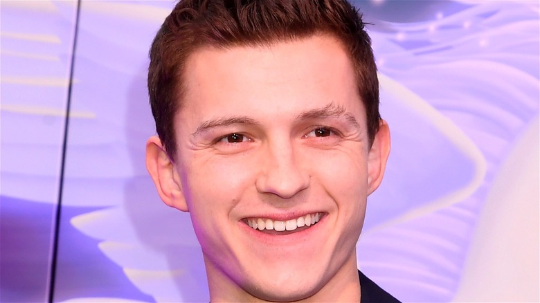 Tom Holland smiling purple background