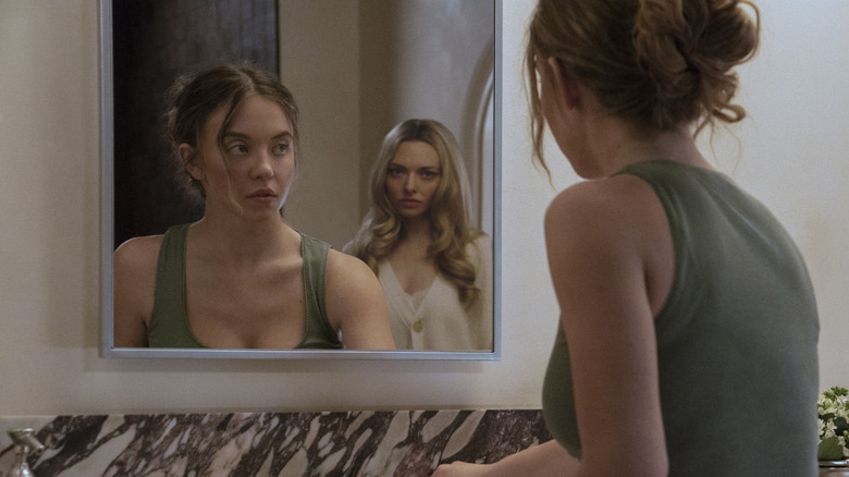 Millie looking in the mirror with Nina behind her in The Housemaid