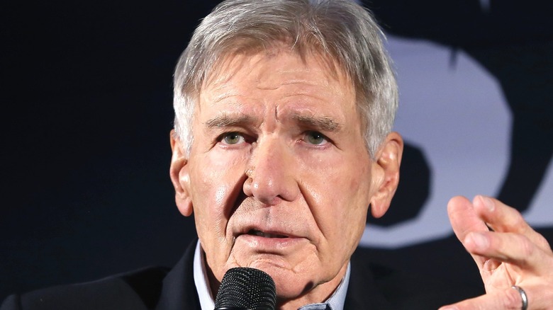 Harrison Ford holding microphone 