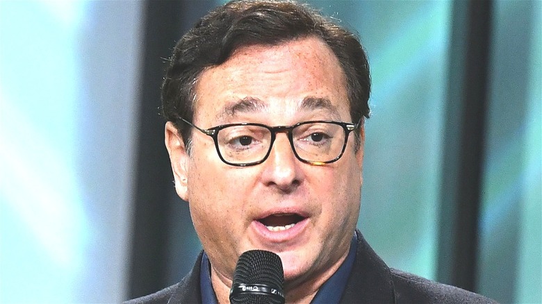 Bob Saget speaking into microphone