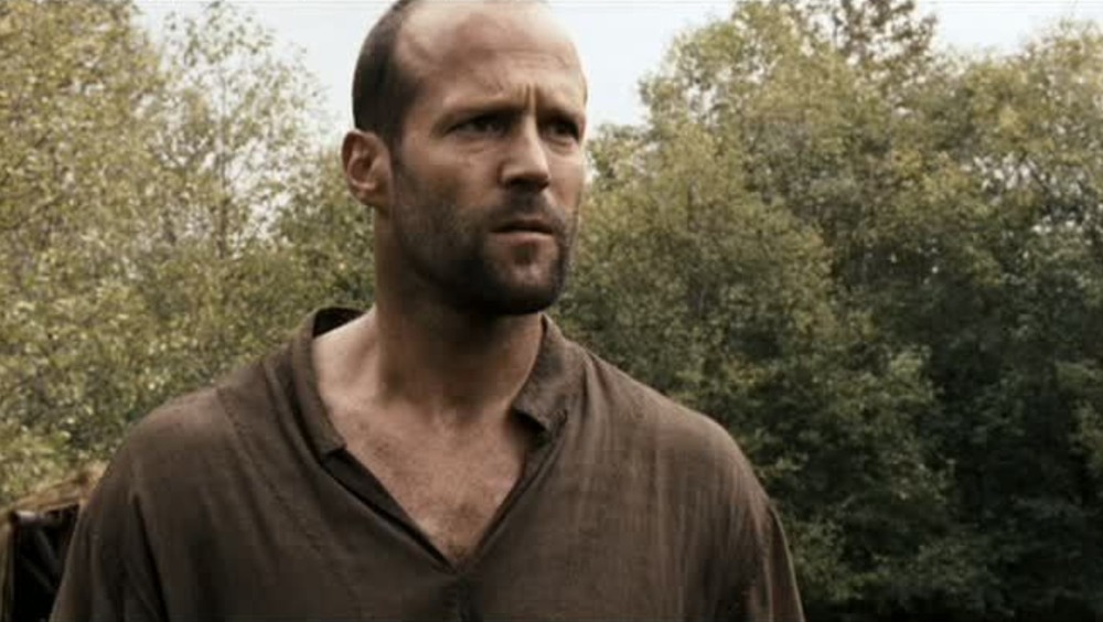Farmer (Jason Statham) stands next to horse in In the Name of the King