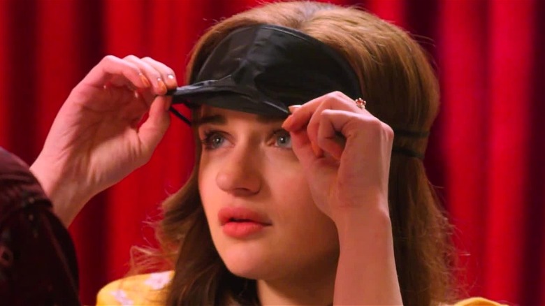 Elle removing her eye mask in 