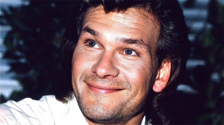 Patrick Swayze smiling, looks up