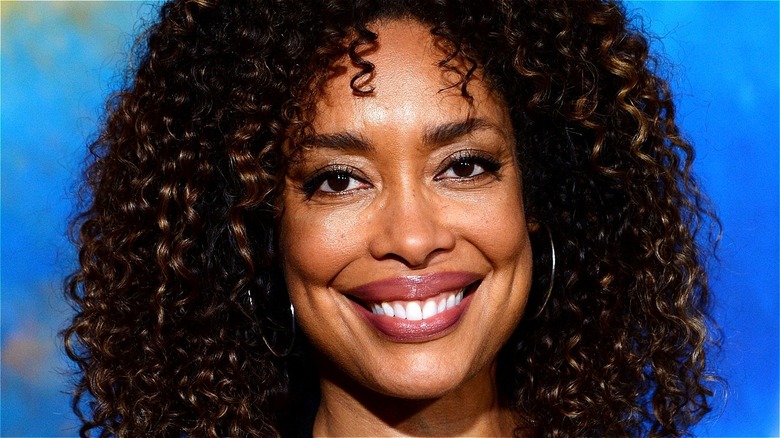 Gina Torres smiling blue background