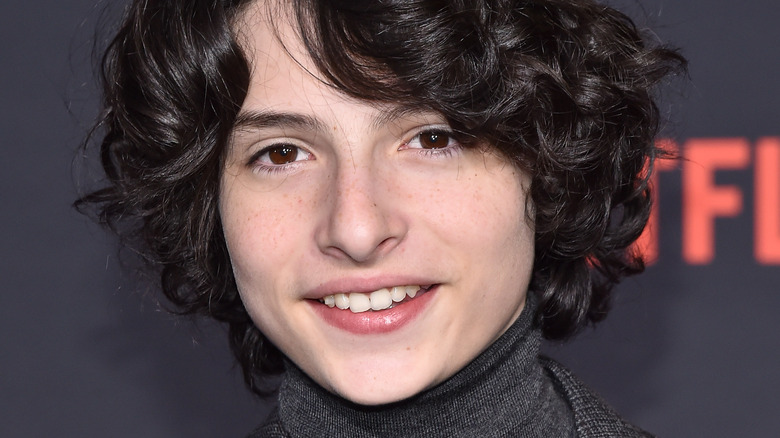 Finn Wolfhard smiling at event