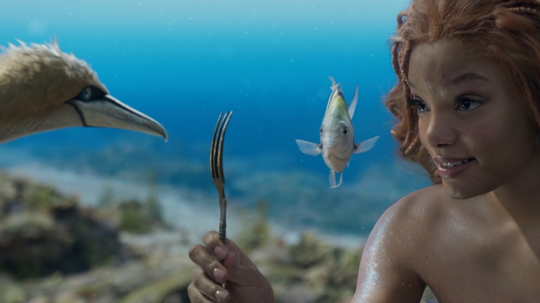 Ariel showing off her fork to Flounder and Scuttle