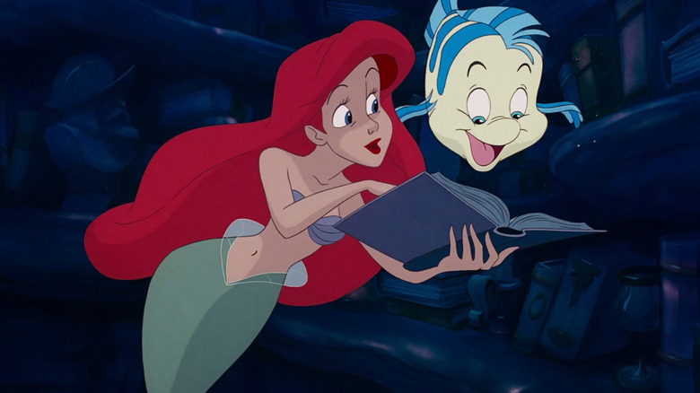 Ariel and Flounder looking at book