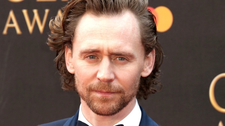 Tom Hiddleston smiling on red carpet