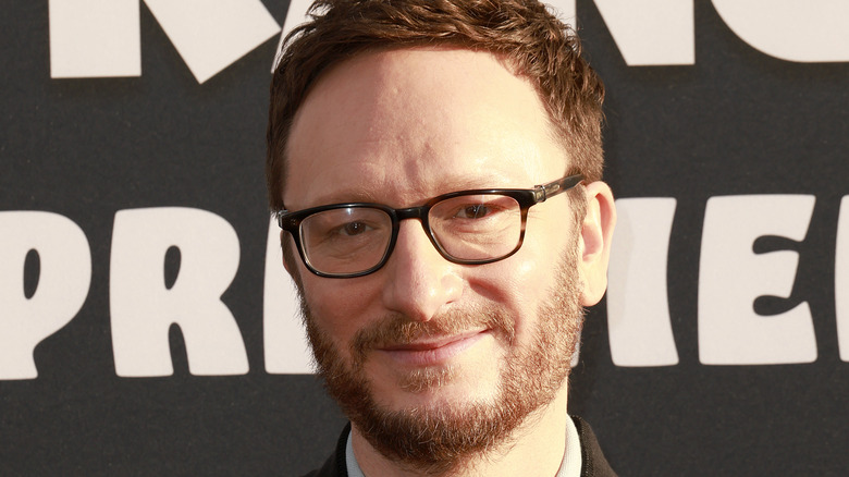 Akiva Schaffer wearing glasses on red carpet