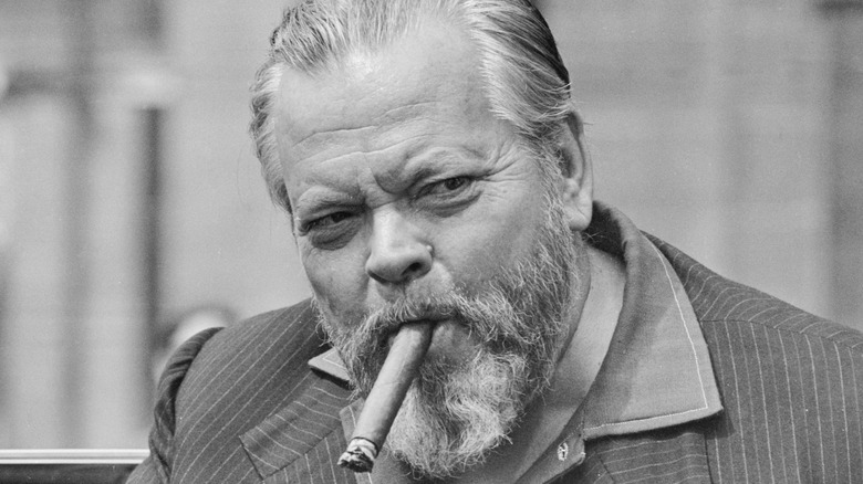 Orson Welles puffs on a cigar