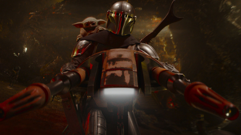 Din Djarin riding a space bike with Grogu on his shoulder in The Mandalorian and Grogu