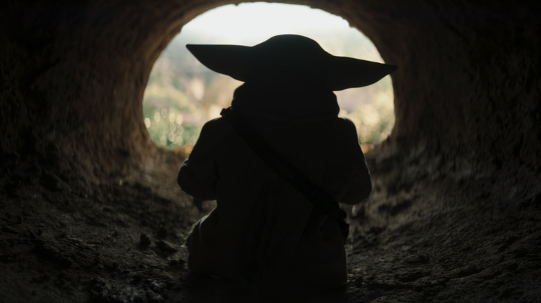 Grogu looking out of a tunnel in The Mandalorian and Grogu