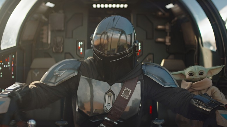 Din Djarin riding ship next to Grogu in The Mandalorian and Grogu