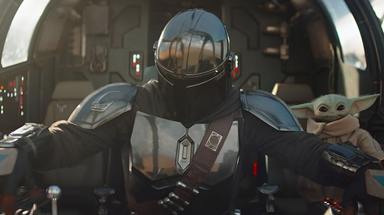 Din Djarin riding ship next to Grogu in The Mandalorian and Grogu
