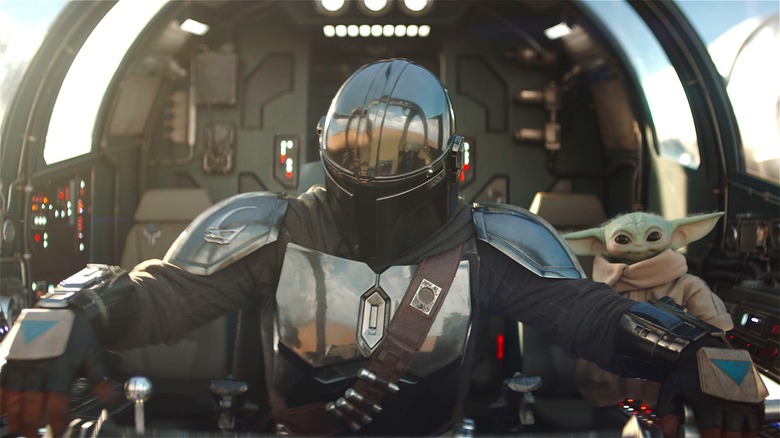 Din Djarin and Grogu in the cockpit of a flying ship in 