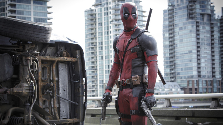 Deadpool standing while holding guns
