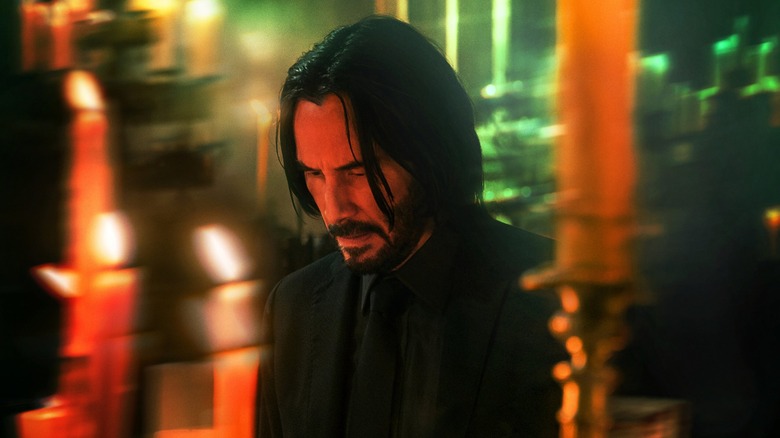 John Wick stands among candles