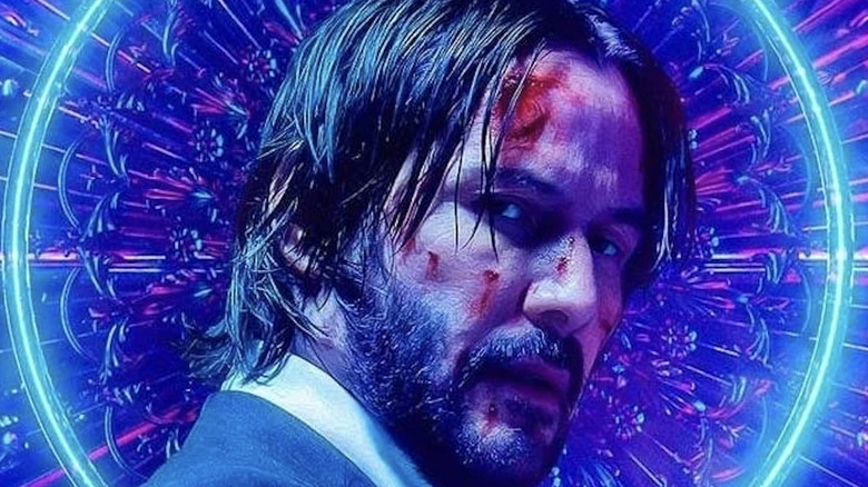 John Wick bruised and holding handgun 