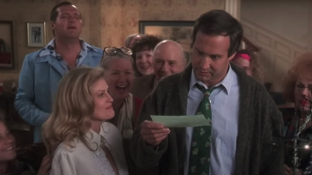 Chevy Chase as Clark, surrounded by the Griswold family, getting his bonus in National Lampoon's Christmas Vacation