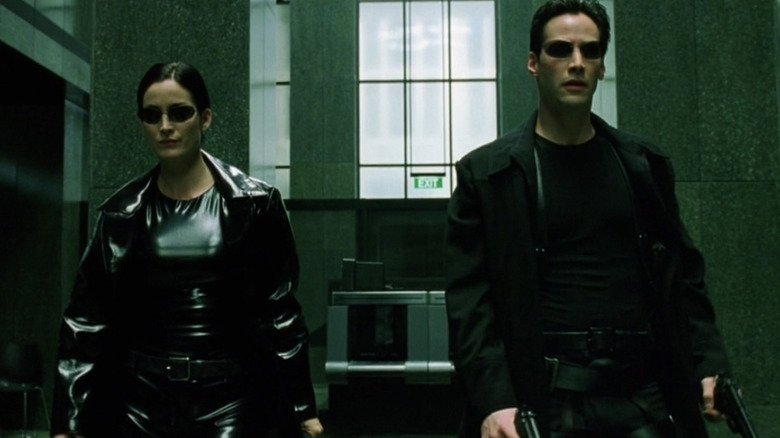 Trinity and Neo walk into a lobby in "The Matrix" (1999)