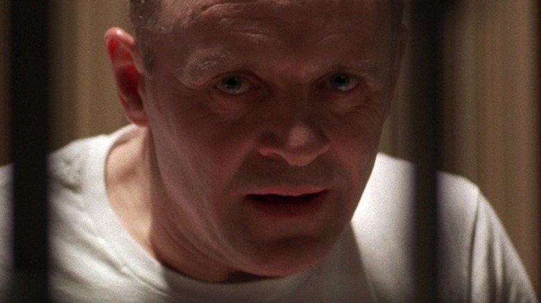 Anthony Hopkins in white prison garb looking through bars