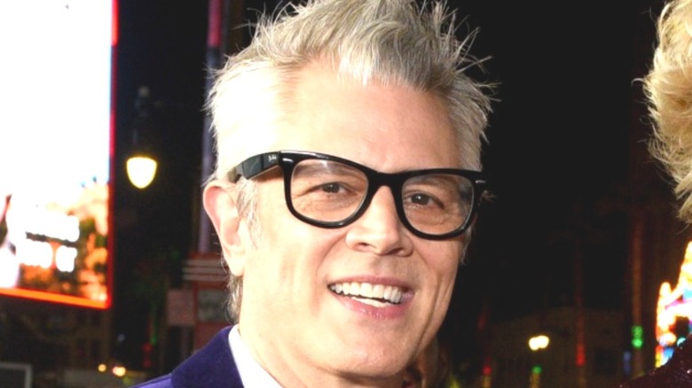 Johnny Knoxville in a suit and black glasses