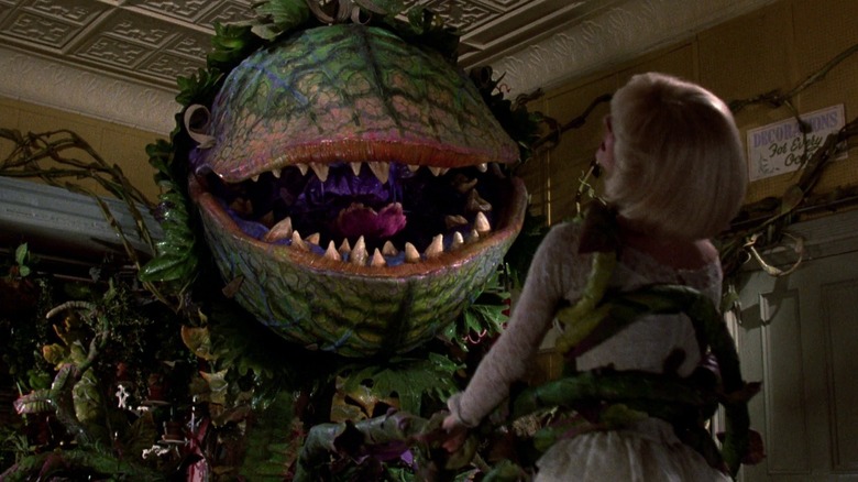 Audrey II holding Audrey in vines
