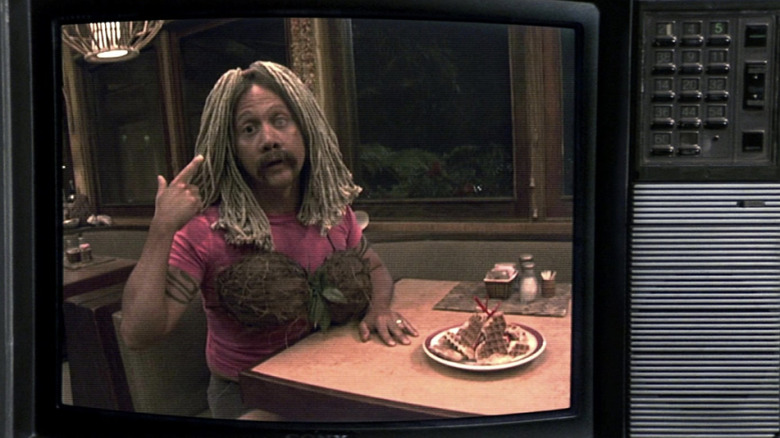 Rob Schneider in drag points to head