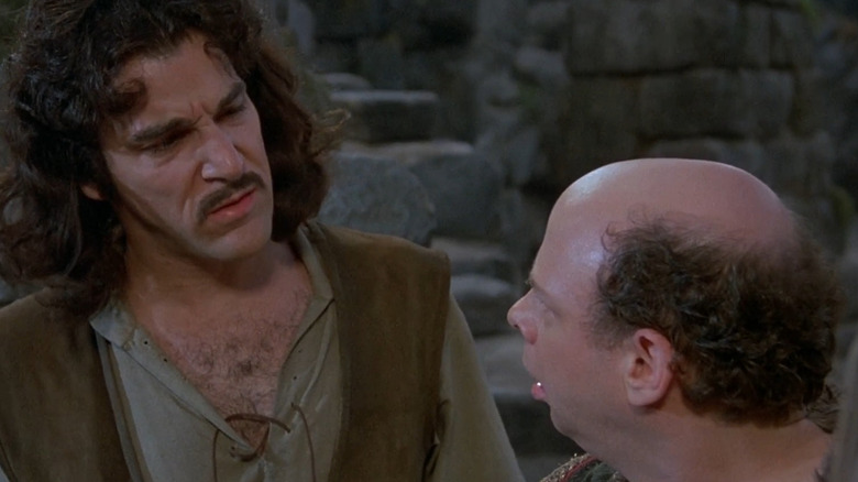 Concerned Mandy Patinkin stares at Wallace Shawn