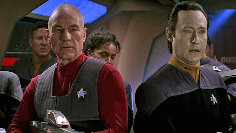 Picard and Data lead a team of heavily armed officers through a corridor aboard the Enterprise.