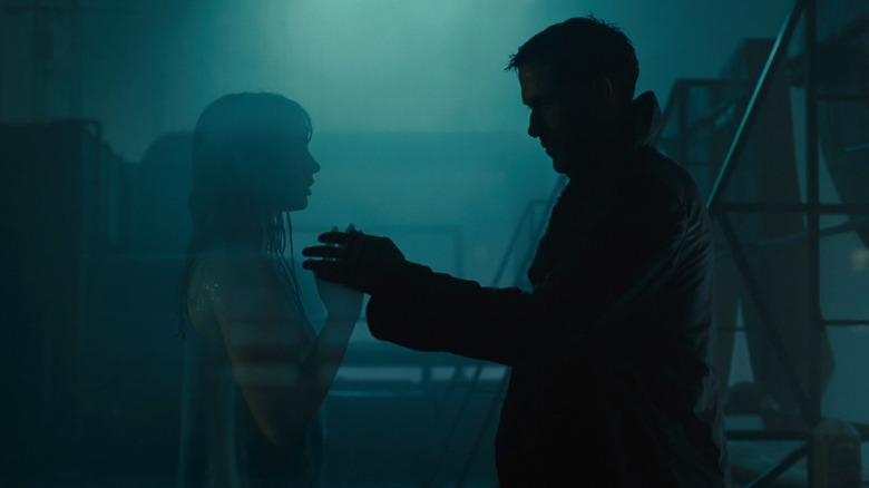 Joi and K hold hands