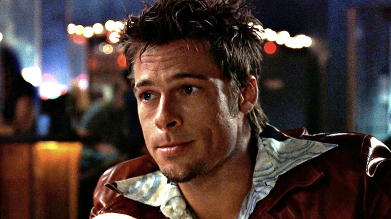 Tyler Durden sits and smirks in Fight Club