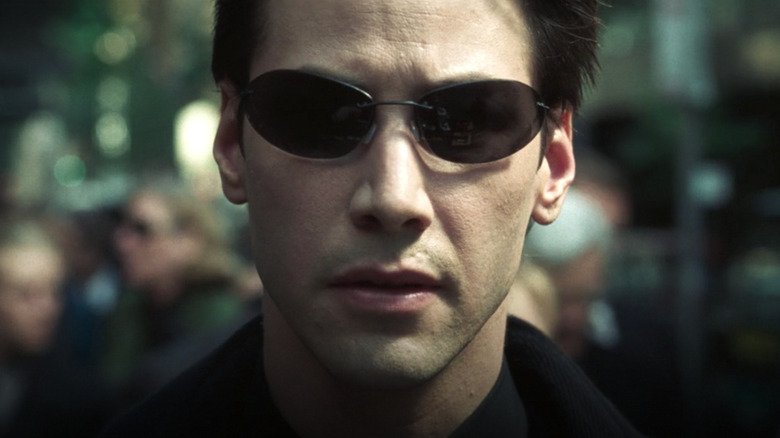 Keanu Reeves as Neo wearing sunglasses in The Matrix