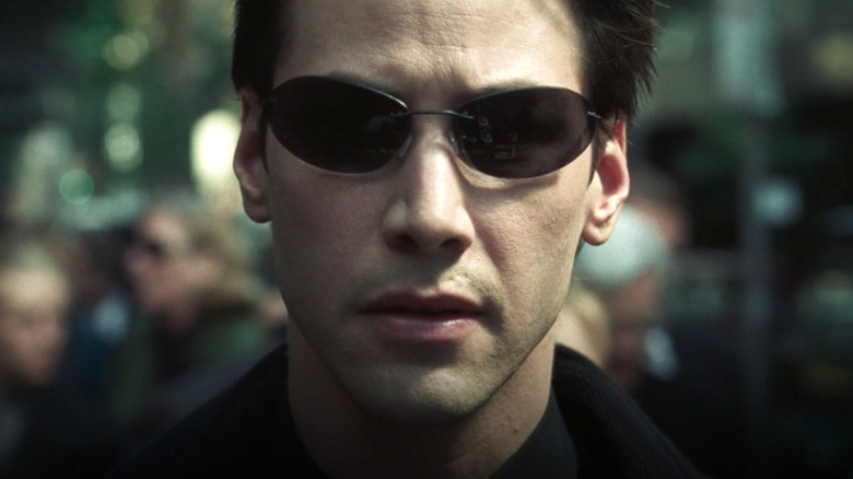 Keanu Reeves as Neo wearing sunglasses in The Matrix