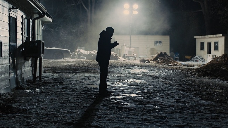 Detective Loki listens to a faint sound outside in "Prisoners" (2013)