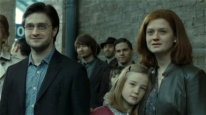 Adult Harry and Ginny standing with their daughter watching their son leave for Hogwarts