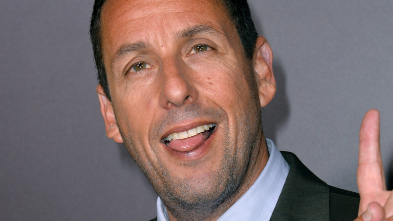 Adam Sandler gives a peace sign