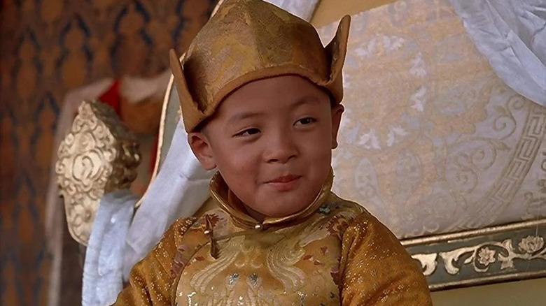 The young Dalai Lama sits on a throne