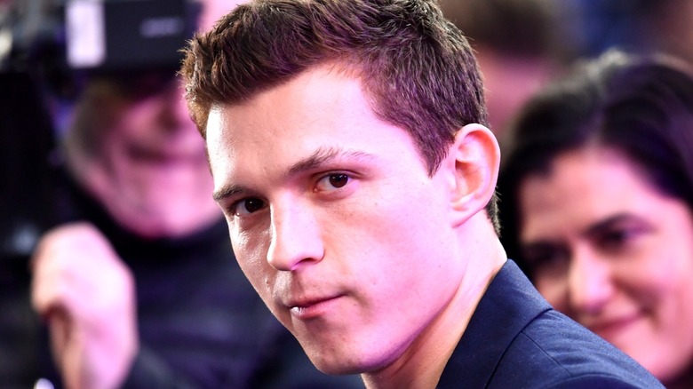 Tom Holland looking into camera at event