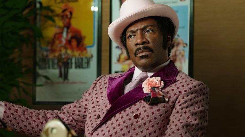 Eddie Murphy sitting in purple suit and hat