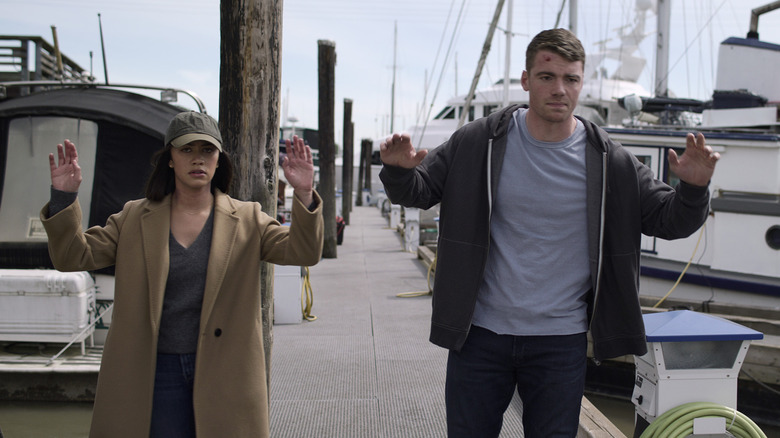 Rose and Peter with their hands up brown jacket
