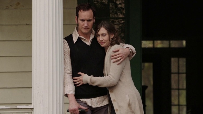 Ed and Lorraine Warren hugging outside house in The Conjuring (2013)