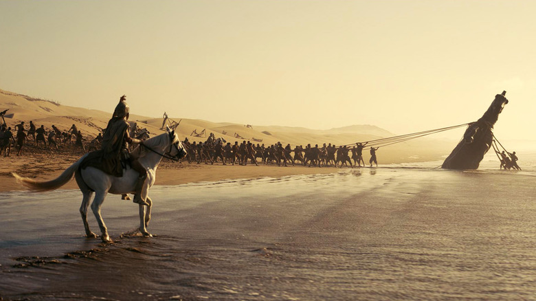 Trojan soldiers pulling the horse out of the sand in The Odyssey (2026)