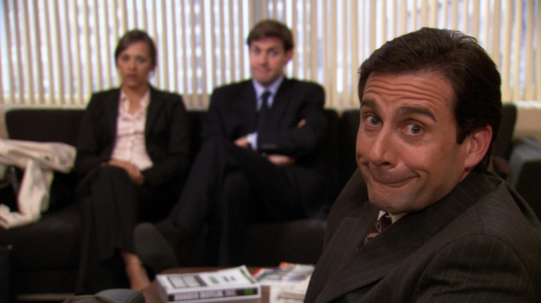 Michael mugging at the camera in front of Karen and Jim in "The Job" (2007)