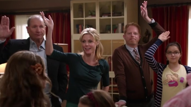Jay, Claire, Mitchell, and Alex raising their hands in Modern Family