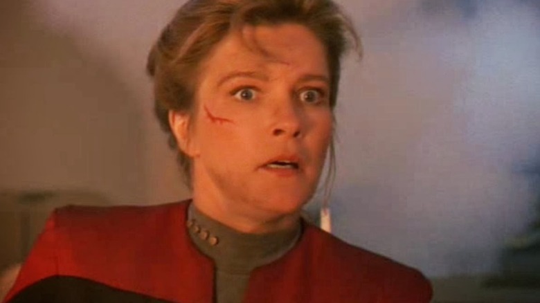 Captain Janeway looking shocked and injured on Voyager's smoky bridge in "Star Trek: Voyager"